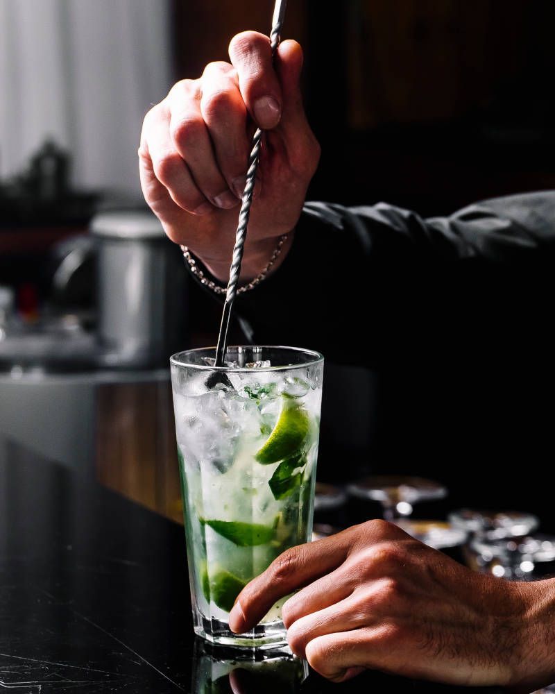 Mojito còctel Imatge de vista lateral de còctel mojito. Rom amb llima, menta i gel a un got.